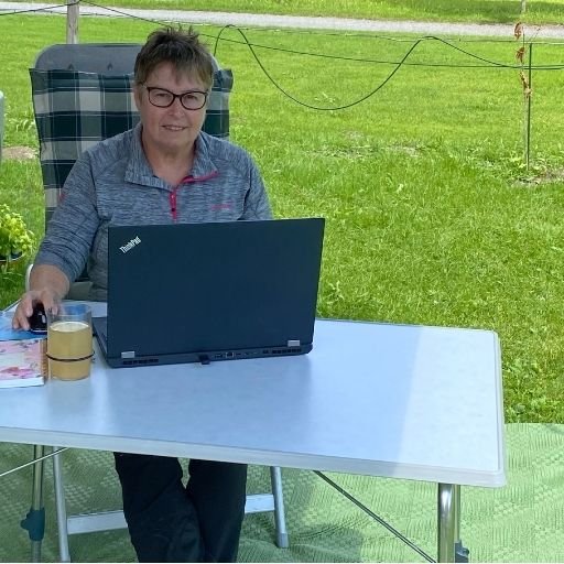 Manuela Bletzer arbeitet mit dem Laptop auf einem Campingplatz